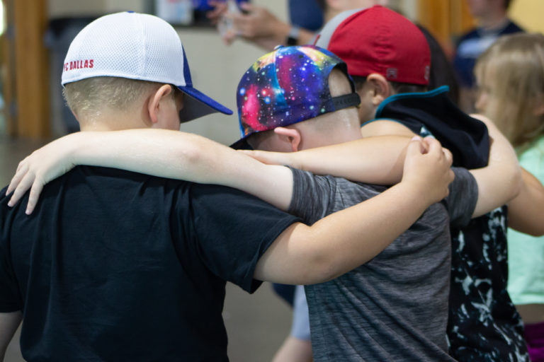 Three boys embrace each other at CampCARE 2021. (Grief Counseling Specialist)