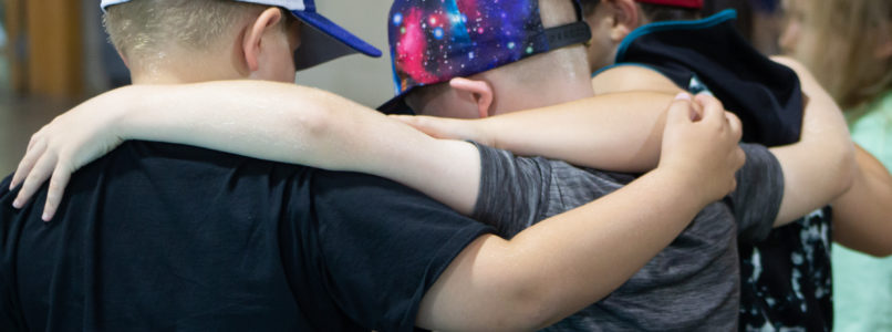 Three boys embrace each other at CampCARE 2021. (Grief Counseling Specialist)