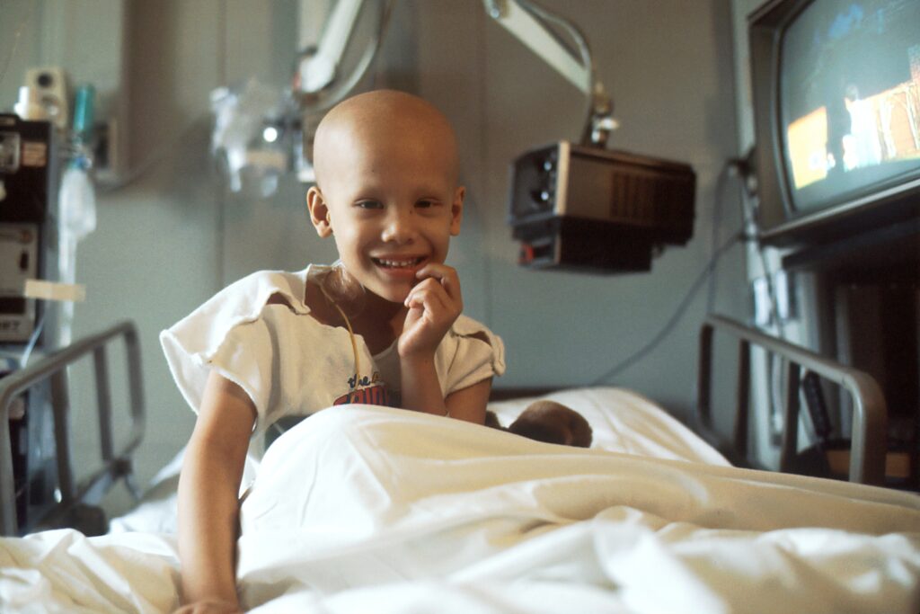 Childhood cancer has impacted the young girl in the hospital bed.