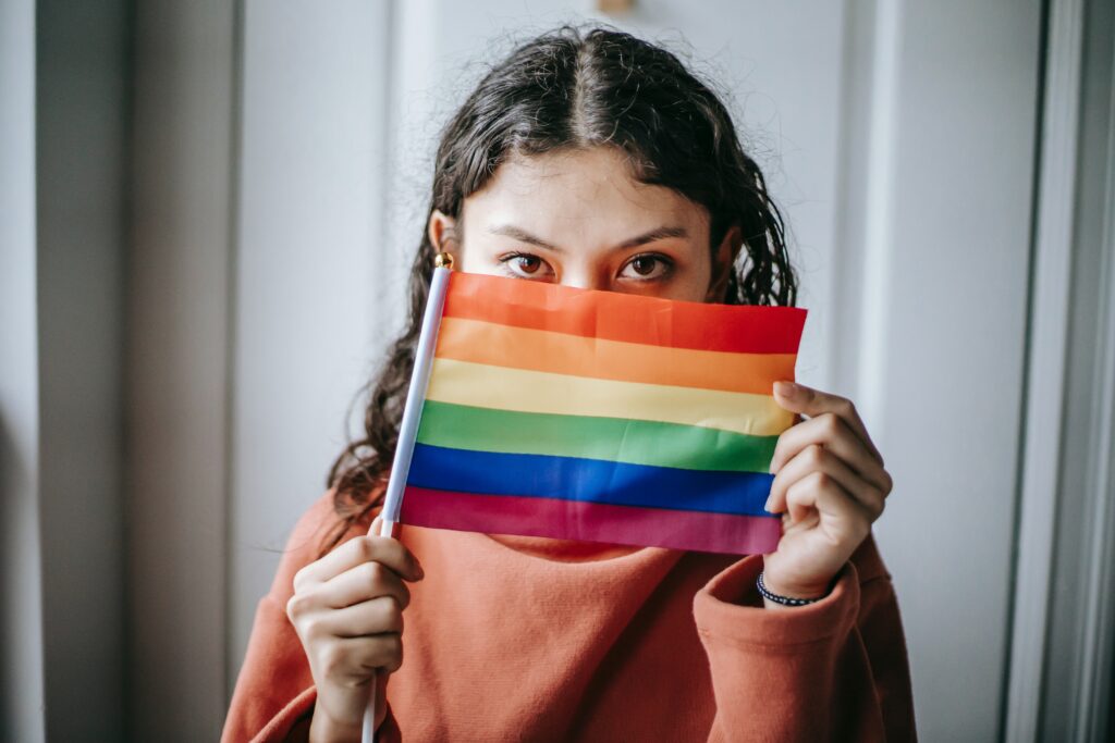 LGBTQ Saves serves youth like the young woman holding a pride flag.