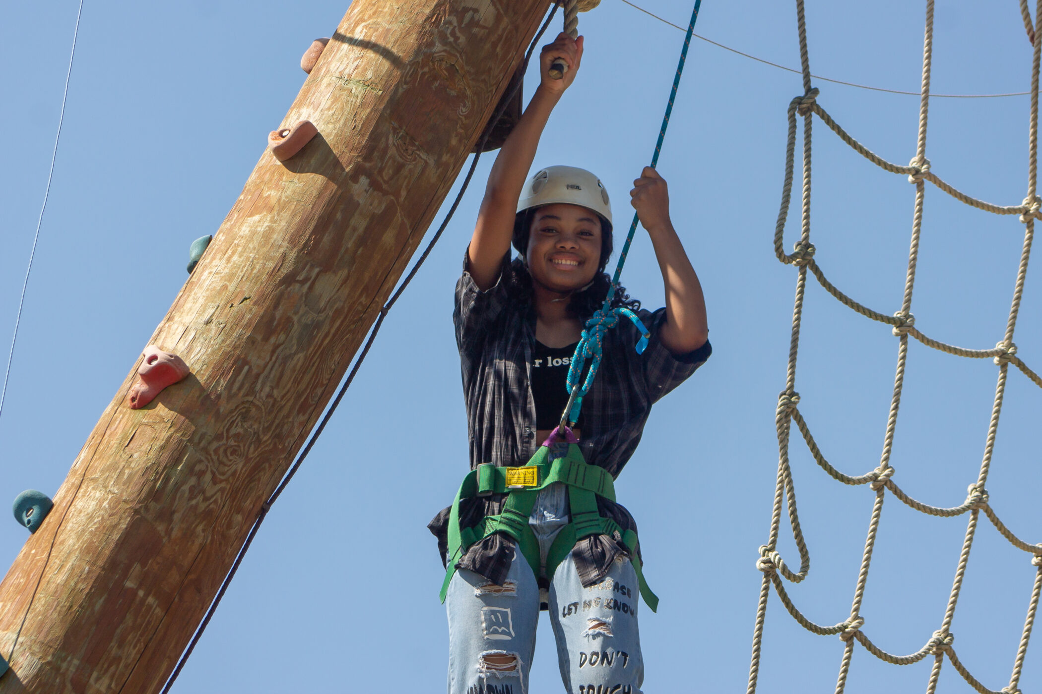 Sanna climbing the apline tower at CampCARE 2022.