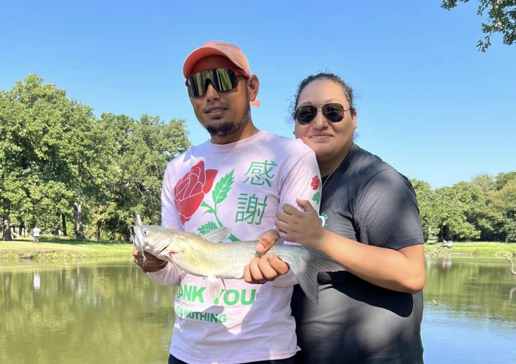 A couple poses with a fish at Reel Connection 2022.