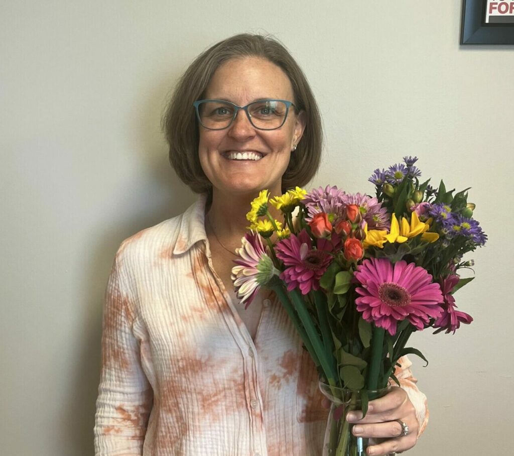Jackie Gibbons poses with flowers for National Volunteer Month.