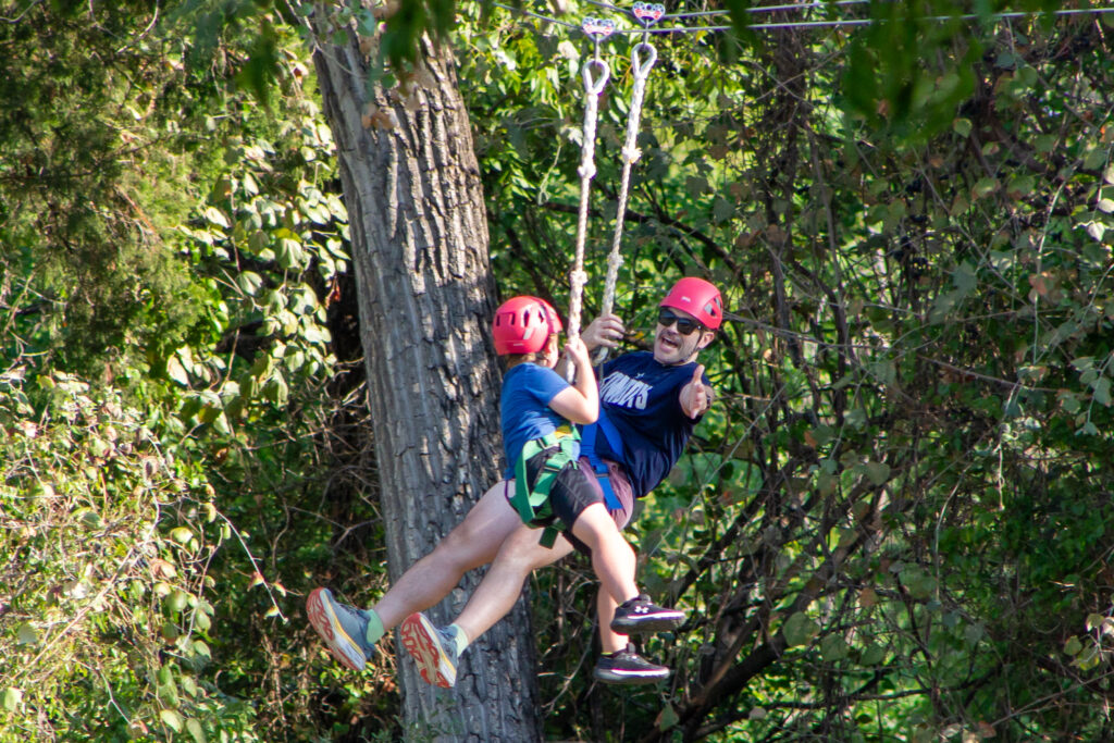 A dad and son zipline at Camp Connect 2023.