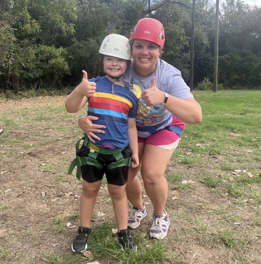 Megan and a young camper pose by the zipline.