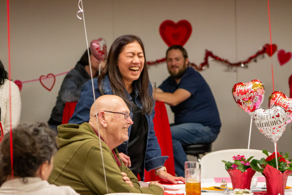 A couple laughs at Cancer Care Services' Valentine's Dinner 2024.