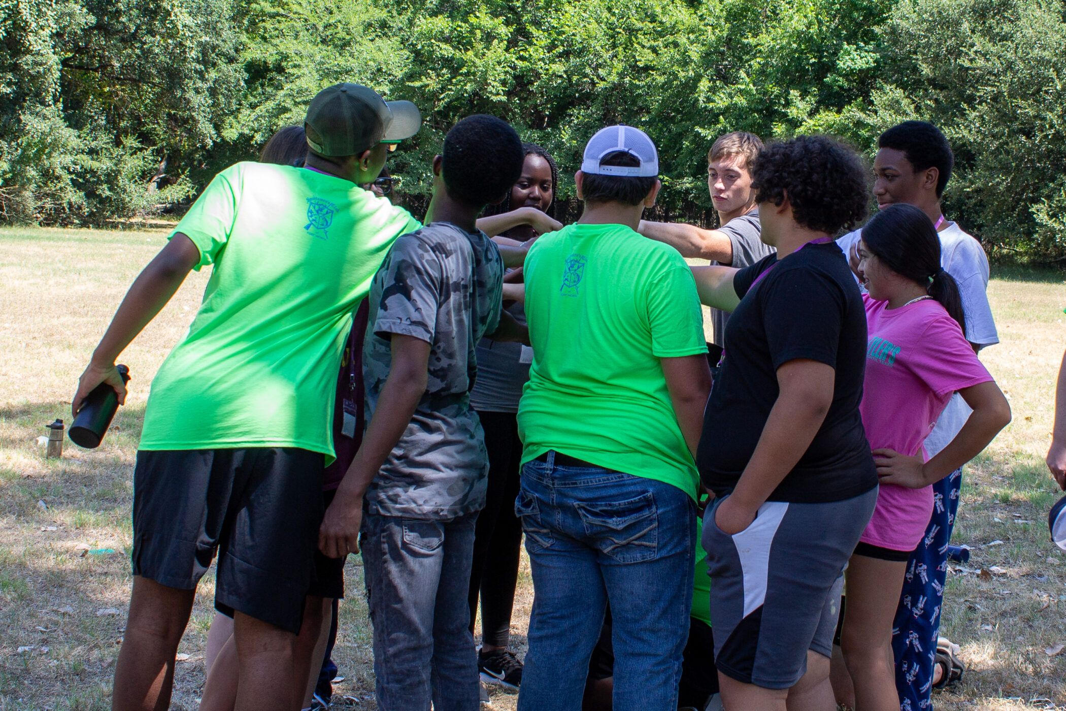 A group of teens tand together in a circle at Teen Retreat.