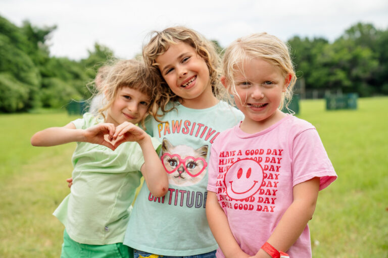 Three girls stand in a group at CampCARE 2024.