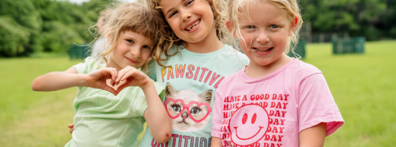 Three girls stand in a group at CampCARE 2024.