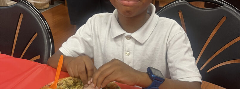 A boy has a full plate of food at Friendsgiving hosted by Cancer Care Services.