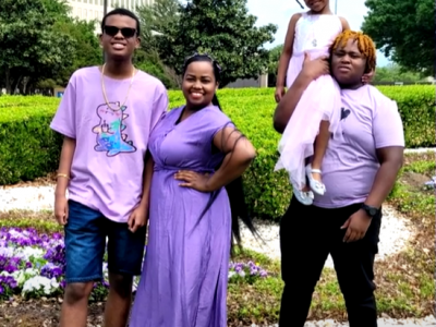A family with a mother, two teenage soons, and a young sister pose together.
